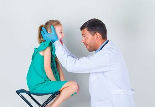 Revisión clínica a una niña por parte de un profesional
